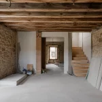 Interior de vivienda en proceso de reforma integral en Burgos con tabiques derribados y estructura vista